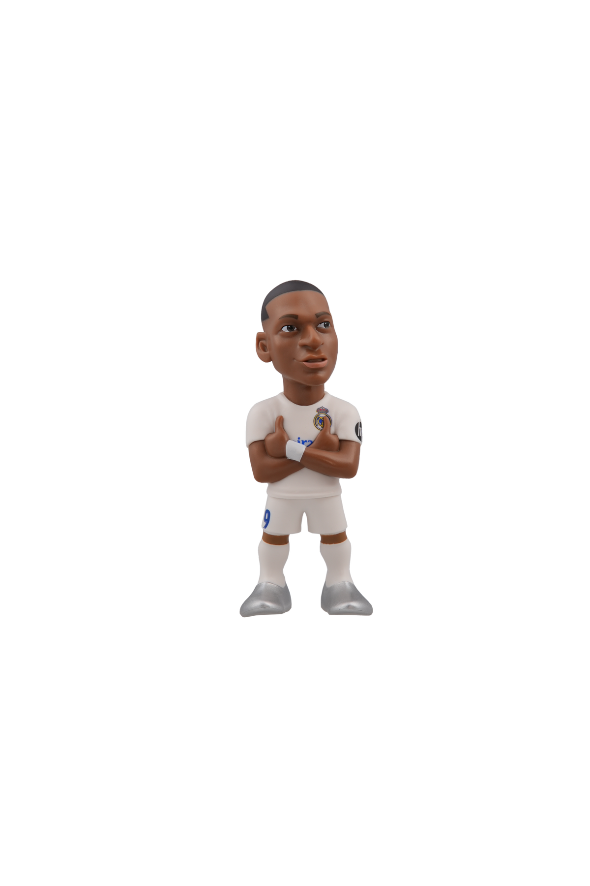 Minix football figurine in a white Real Madrid kit, with crossed arms, dark skin and sculpted facial features.
