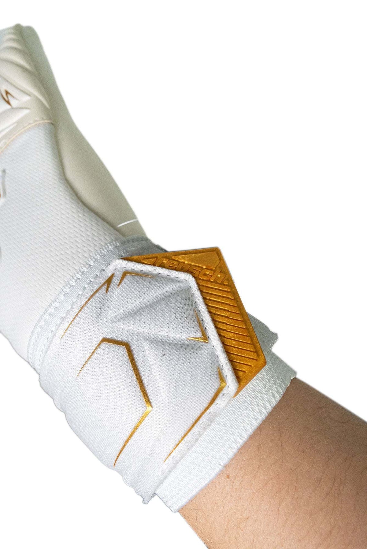 Reusch Attrakt AB1 goalkeeper glove in white latex with gold angular wrist details and a ribbed fastening strap.