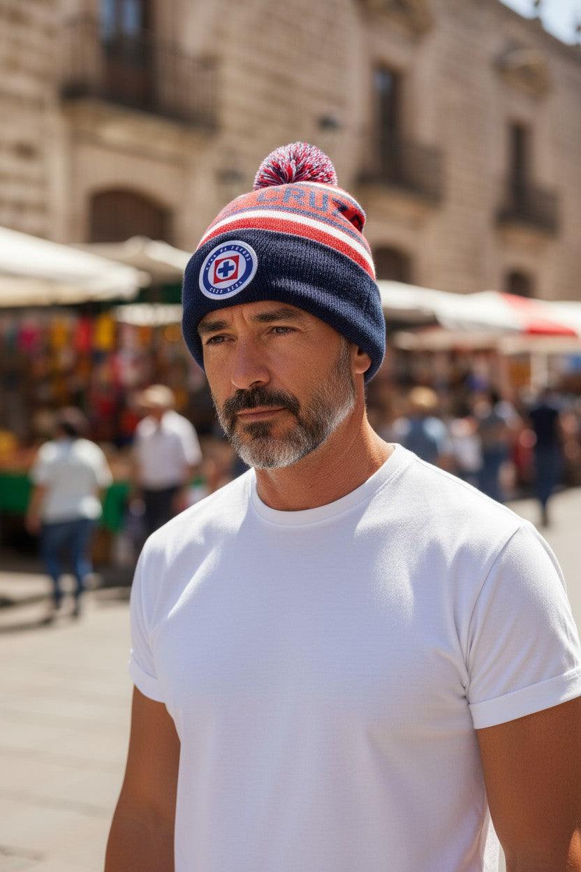 Man wearing Fan Ink unisex premium Football Beanie with embroidered Cruz Azul crest and pom-pom outdoors