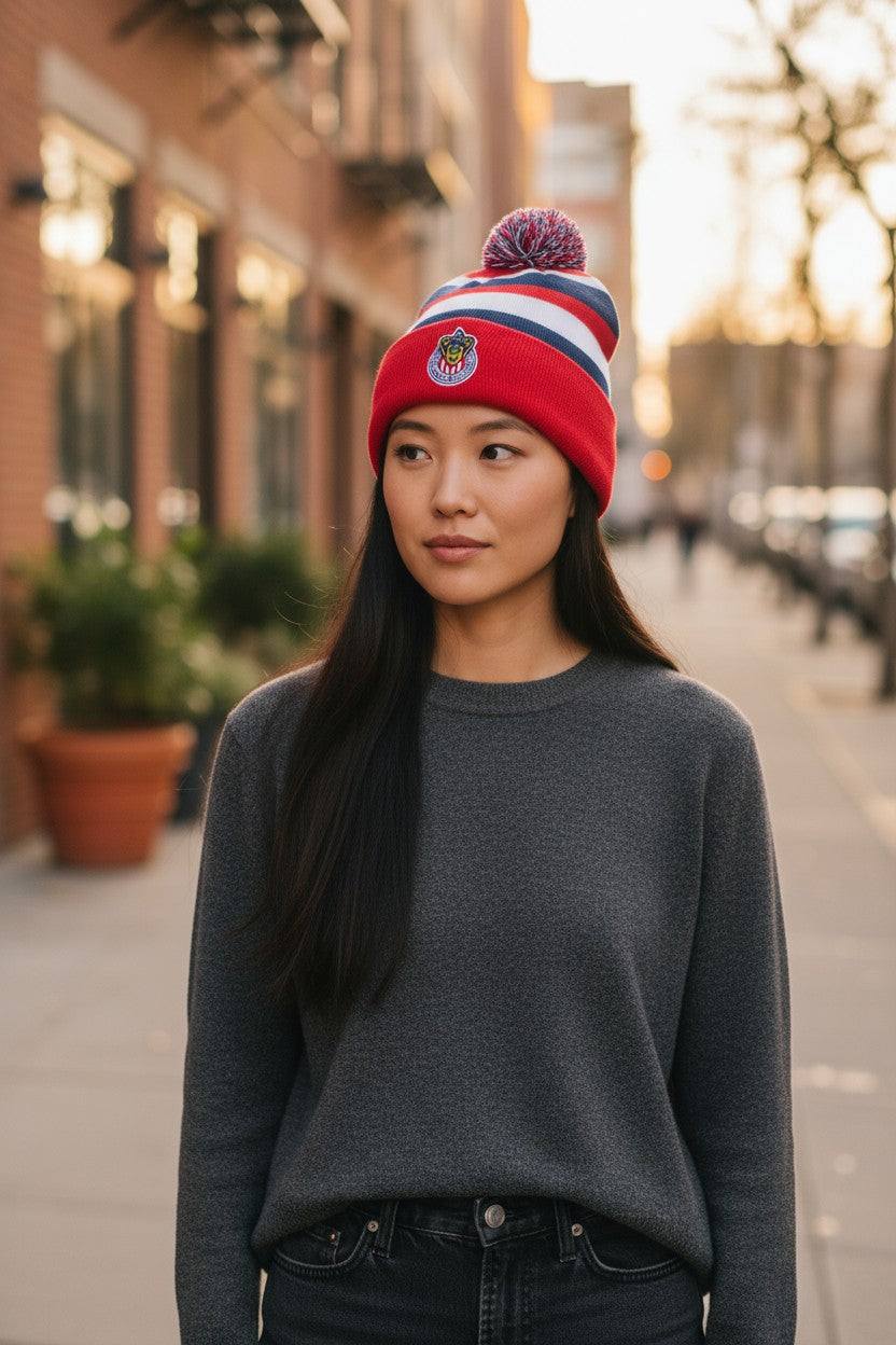 Woman wearing Fan Ink officially licensed Football Beanie with Chivas club crest and pom-pom on city street