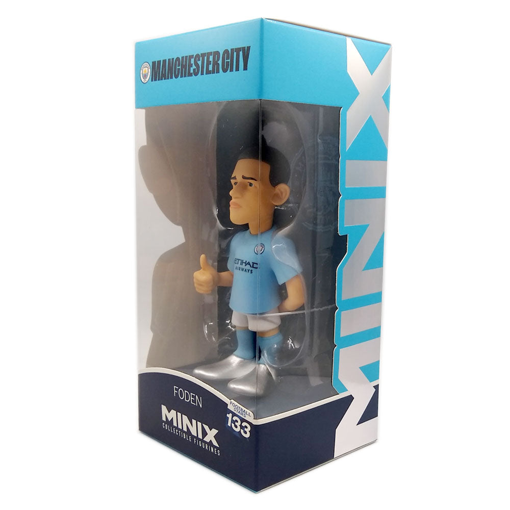 Minix Phil Foden Manchester City figurine in a light blue kit, with oversized head and thumbs-up pose in a display box.