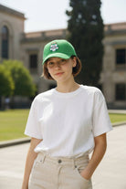 Person wearing a green Fan Ink officially licensed adjustable hat with team logo outdoors