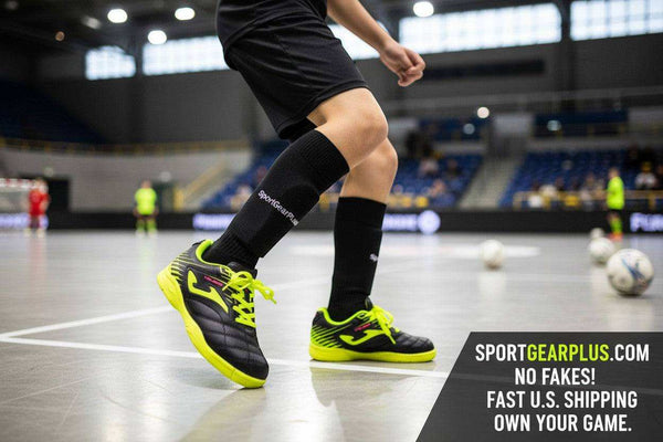 Joma Toledo indoor soccer shoes in black with neon yellow accents, worn by a player on a court