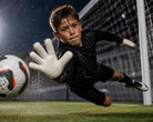 Reusch Attrakt Advance junior goalkeeper gloves black and orange with finger support and breathable fit
