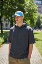 Young man wearing a blue Fan Ink Officially Licensed Adjustable Hat -Top Clubs outdoors
