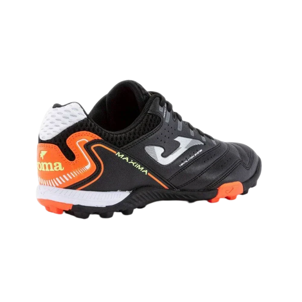Joma Maxima turf soccer shoe in black synthetic material with orange accents, white logo and rubber turf studs