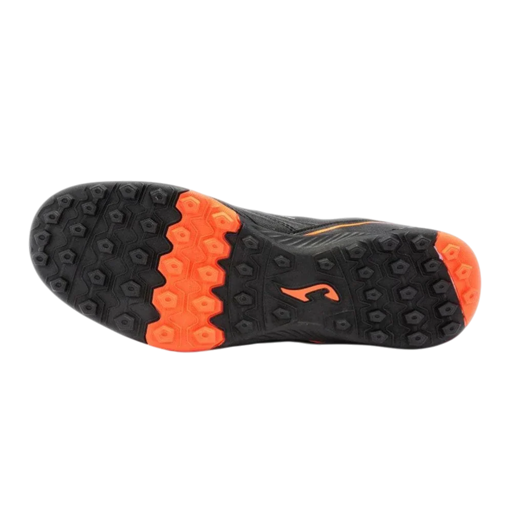 Joma Maxima turf soccer shoe with a black rubber outsole, bright orange multi-directional studs and molded traction pattern