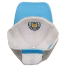 Manchester City Two-Tone Adjustable Cap in sky blue and white, showing the embroidered club crest inside and a blue snapback strap.